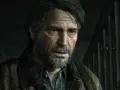 Zmęczony Joel z blizną na policzku, w brązowej kurtce, wygląda jakby czekał na wydarzenia z The Last of Us 3.