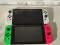 Dwa konsole Nintendo Switch OLED, biała i neonowo-różowa z zielonym Joy-Conem, gotowe na premierę.
