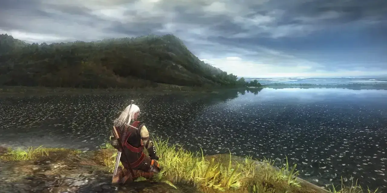 Geralt klęczy nad jeziorem, wpatrując się w horyzont. Wizualizacje z wiedzmin 1 remake zapierają dech w piersiach.