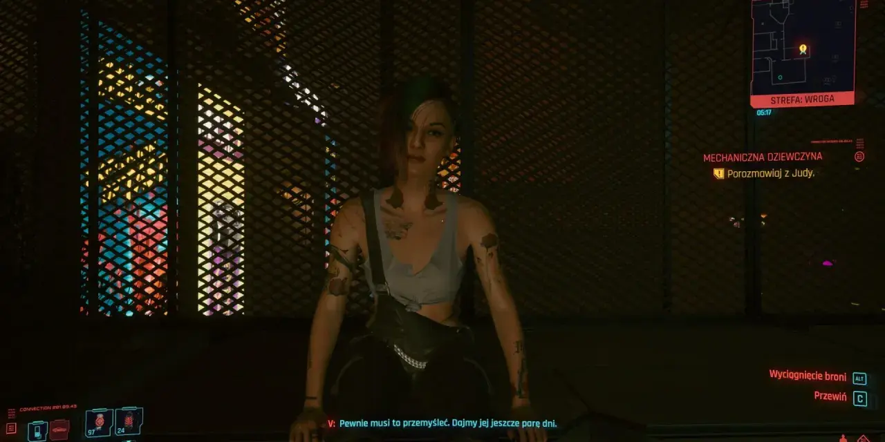 Dziewczyna w stylu czarne czy czerwone cyberpunk, z tatuażami i zielonymi włosami, siedzi na tle neonowych świateł.