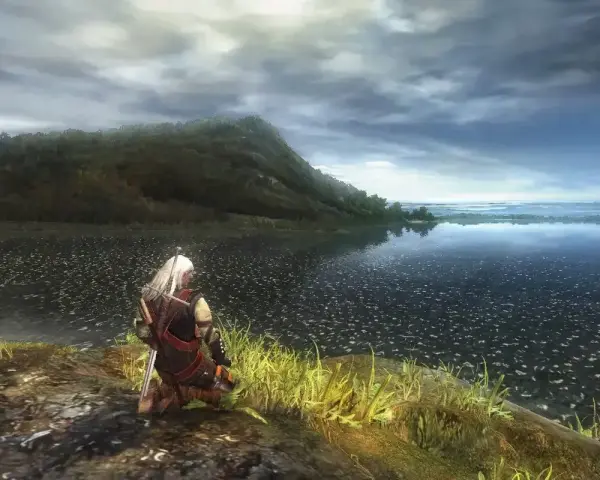 Geralt klęczy nad jeziorem, wpatrując się w horyzont. Wizualizacje z wiedzmin 1 remake zapierają dech w piersiach.