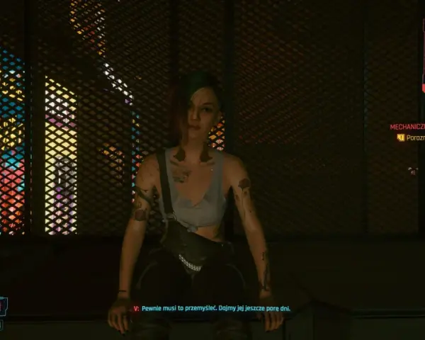 Dziewczyna w stylu czarne czy czerwone cyberpunk, z tatuażami i zielonymi włosami, siedzi na tle neonowych świateł.