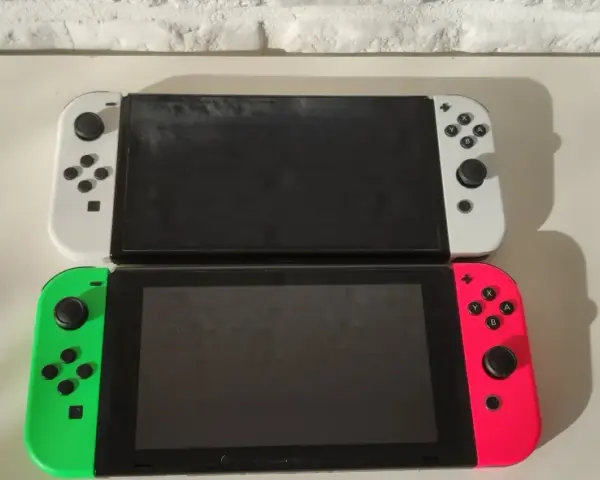 Dwa konsole Nintendo Switch OLED, biała i neonowo-różowa z zielonym Joy-Conem, gotowe na premierę.