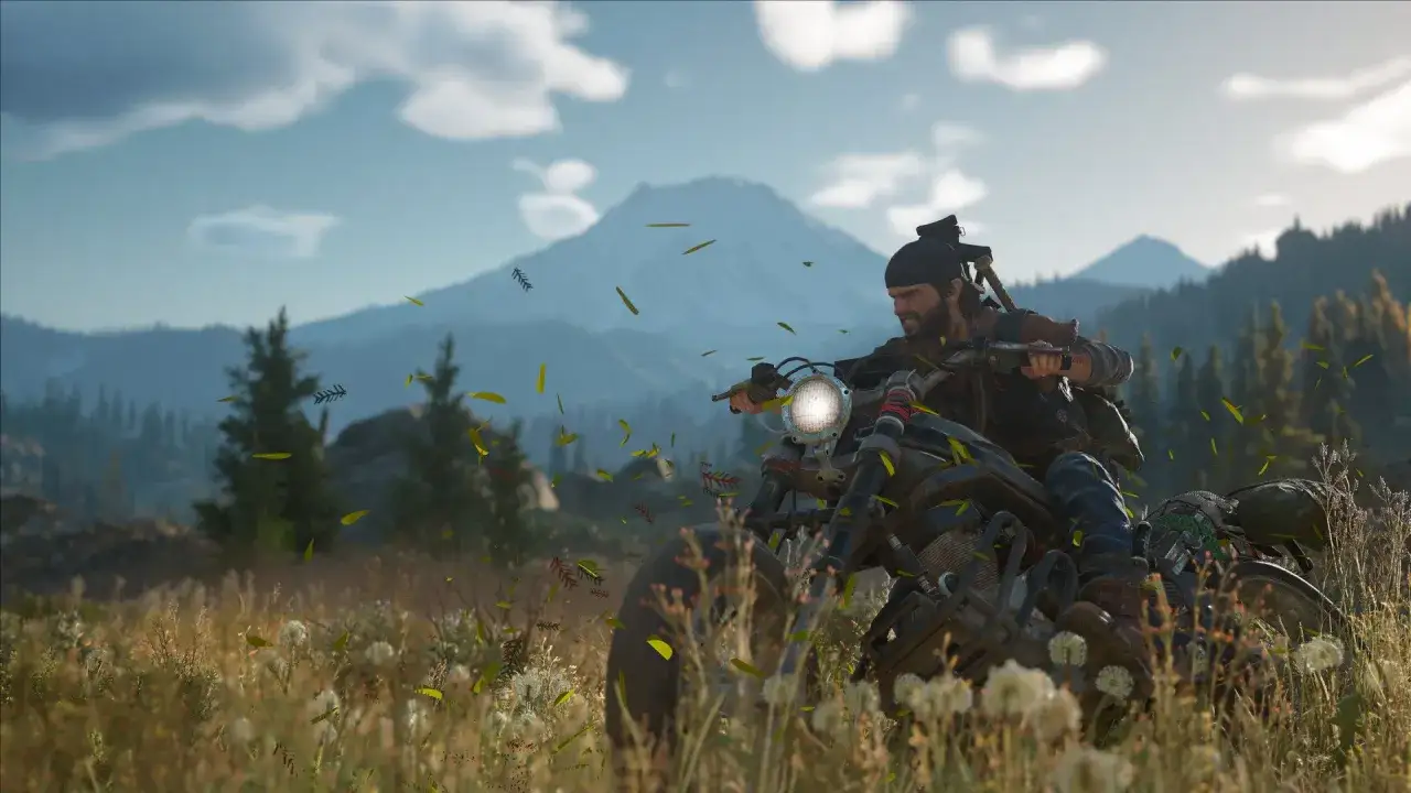 Deacon na motocyklu przemierza dzikie tereny, czekając na premierę Days Gone 2. W tle góry i lasy.